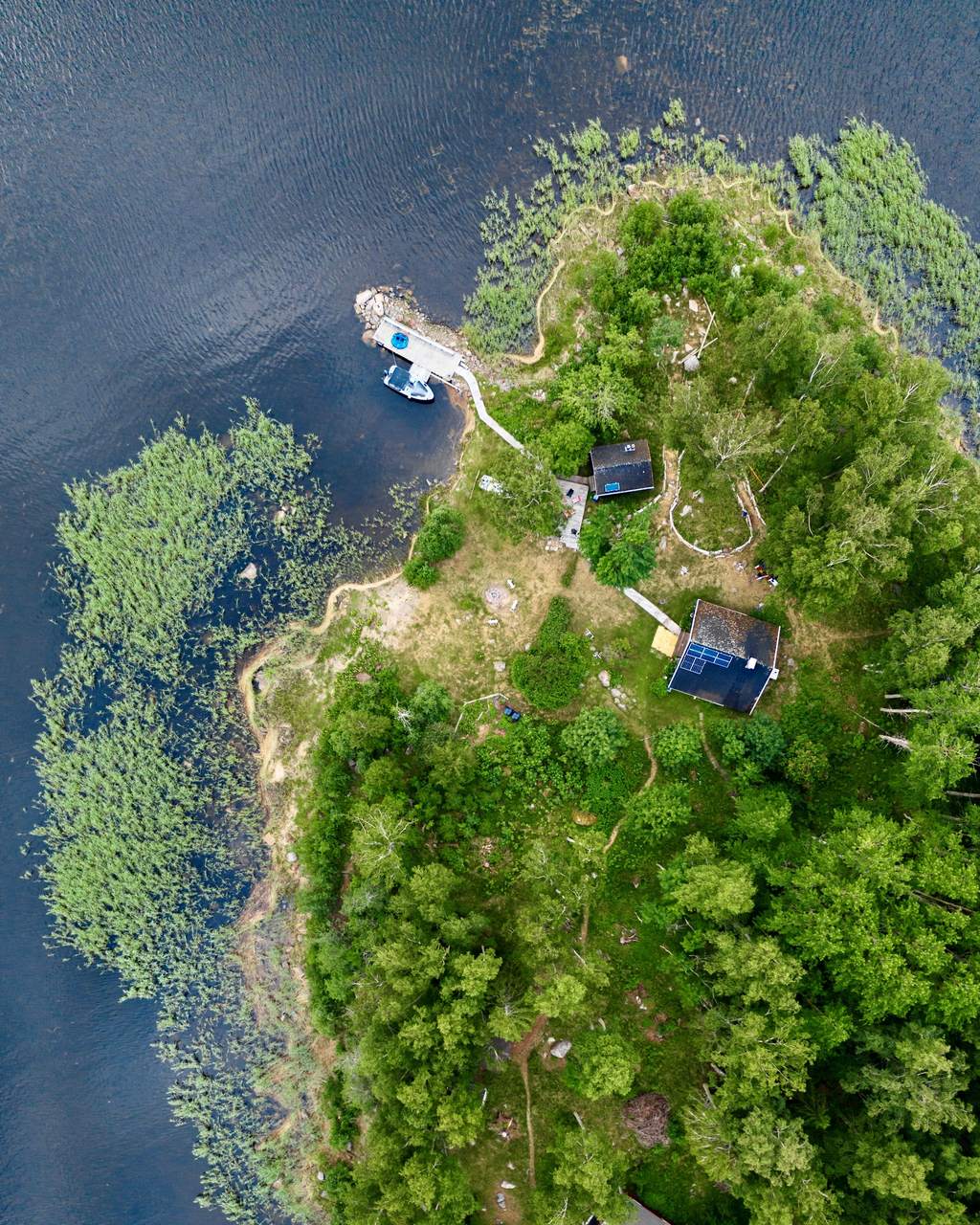 Majorsgrund straight from above: the pier, the houses and their solar panels between the trees